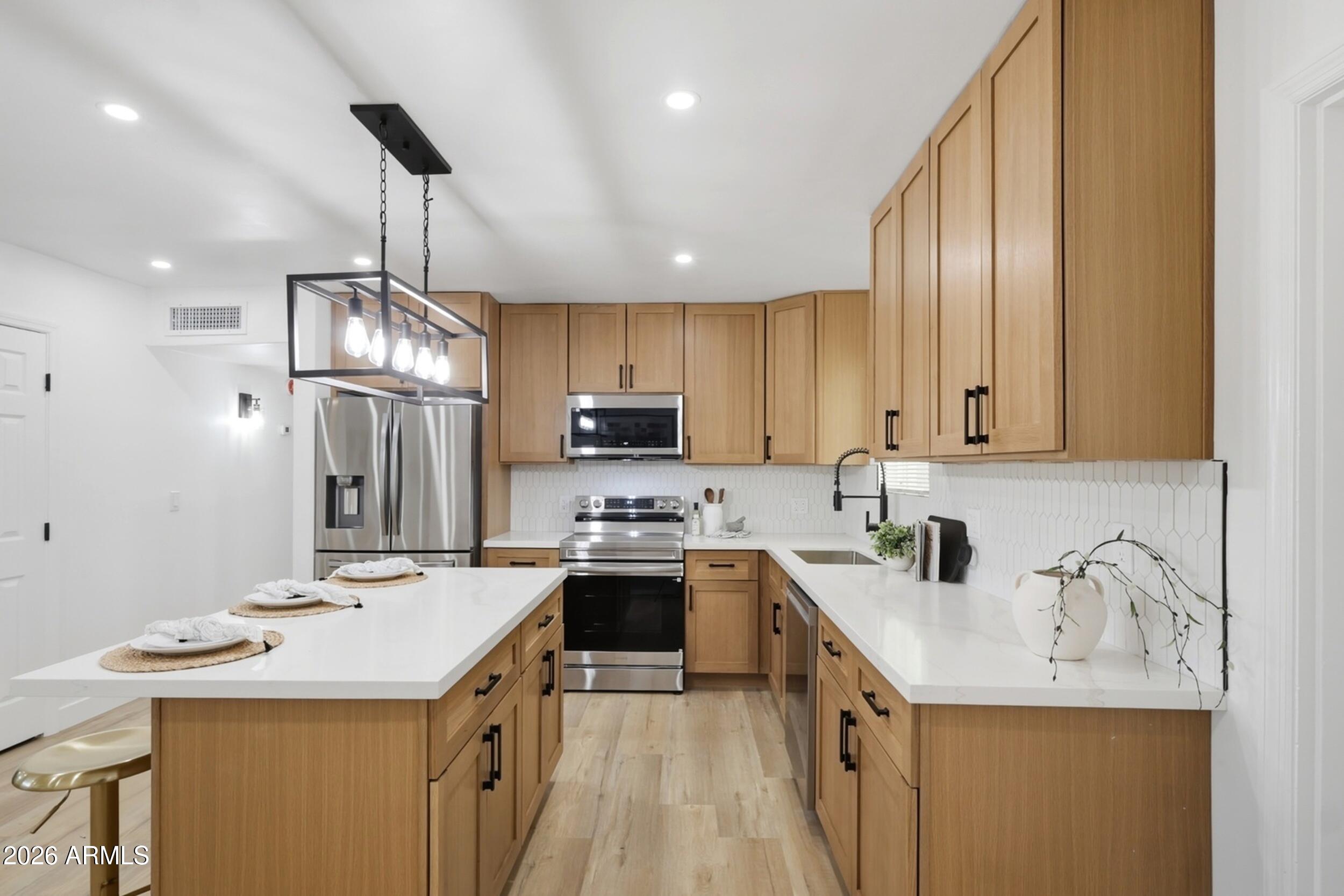 1555 West 6th Street Tempe, AZ 85281 - Photo 11 of 40 a kitchen with a sink a stove a refrigerator and cabinets