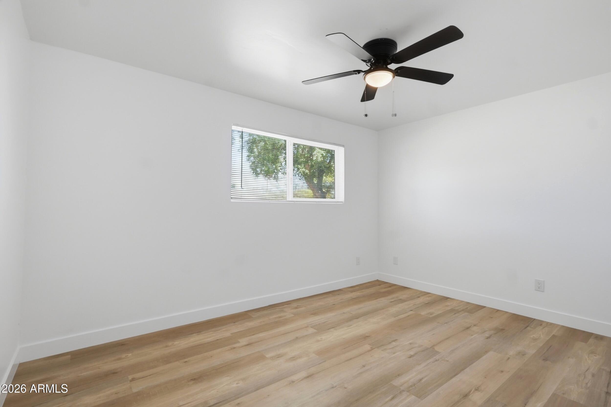 1555 West 6th Street Tempe, AZ 85281 - Photo 15 of 40 an empty room with wooden floor and ceiling fan