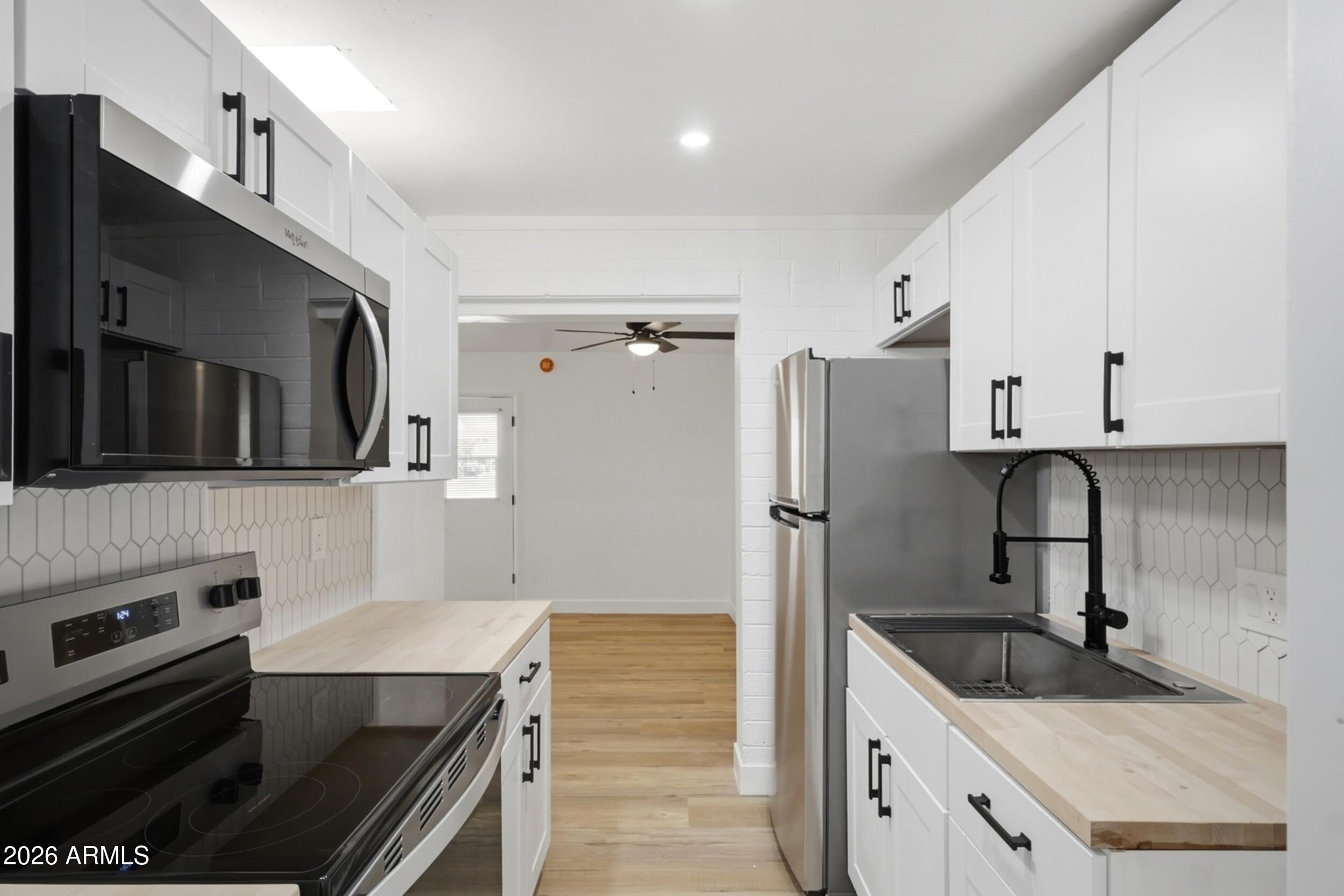 1555 West 6th Street Tempe, AZ 85281 - Photo 23 of 40 a kitchen with stainless steel appliances granite countertop a sink stove and refrigerator