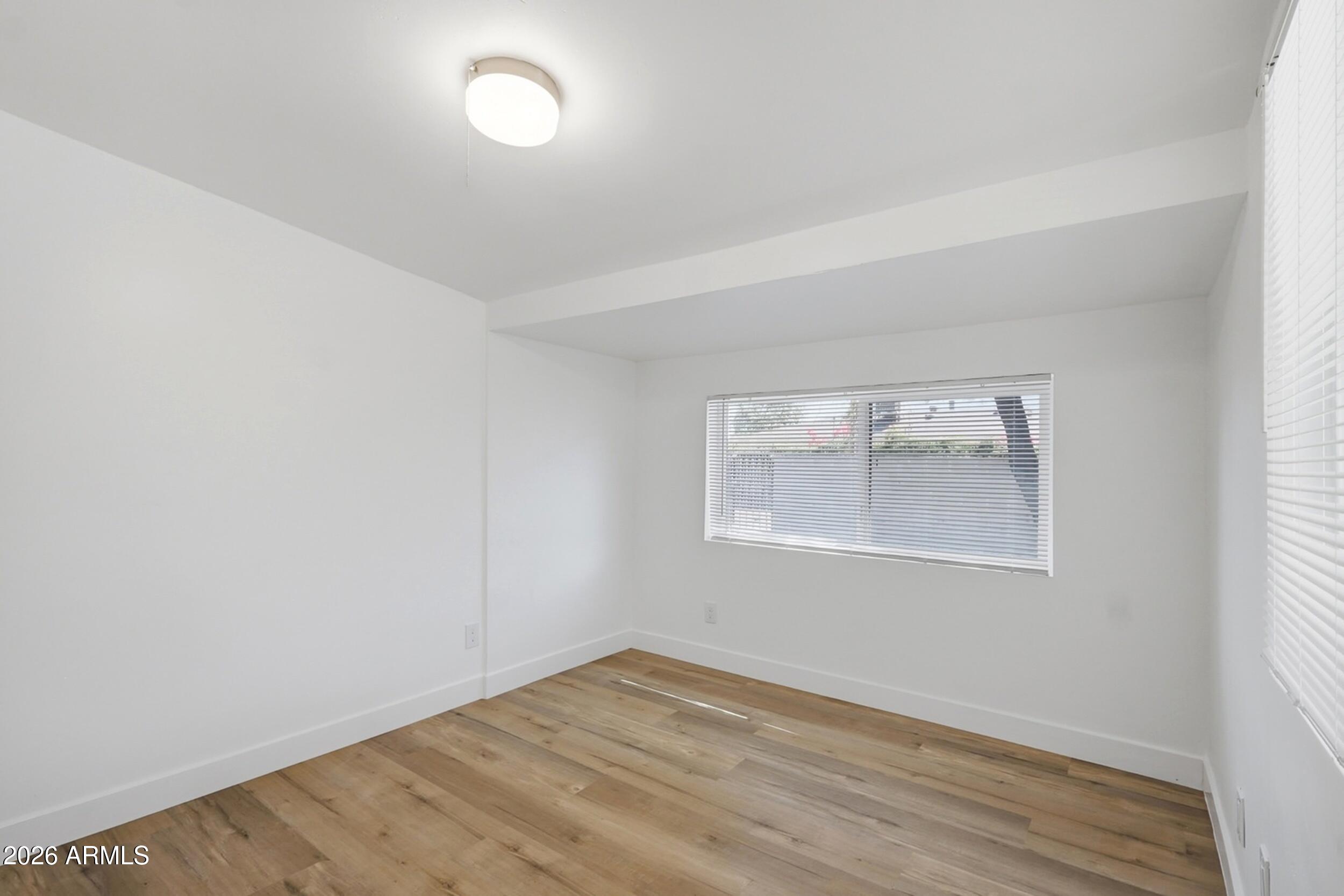 1555 West 6th Street Tempe, AZ 85281 - Photo 24 of 40 an empty room with wooden floor and windows