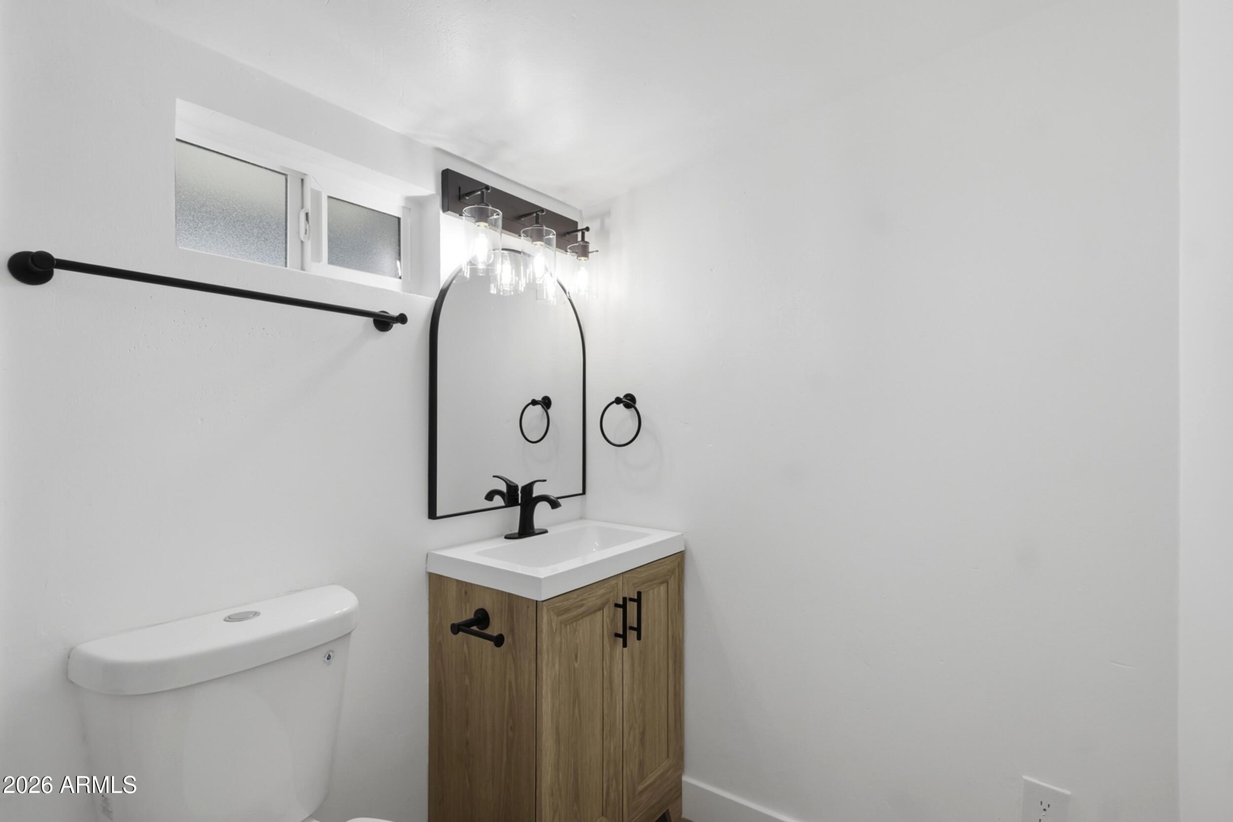 1555 West 6th Street Tempe, AZ 85281 - Photo 27 of 40 a bathroom with a toilet sink and mirror