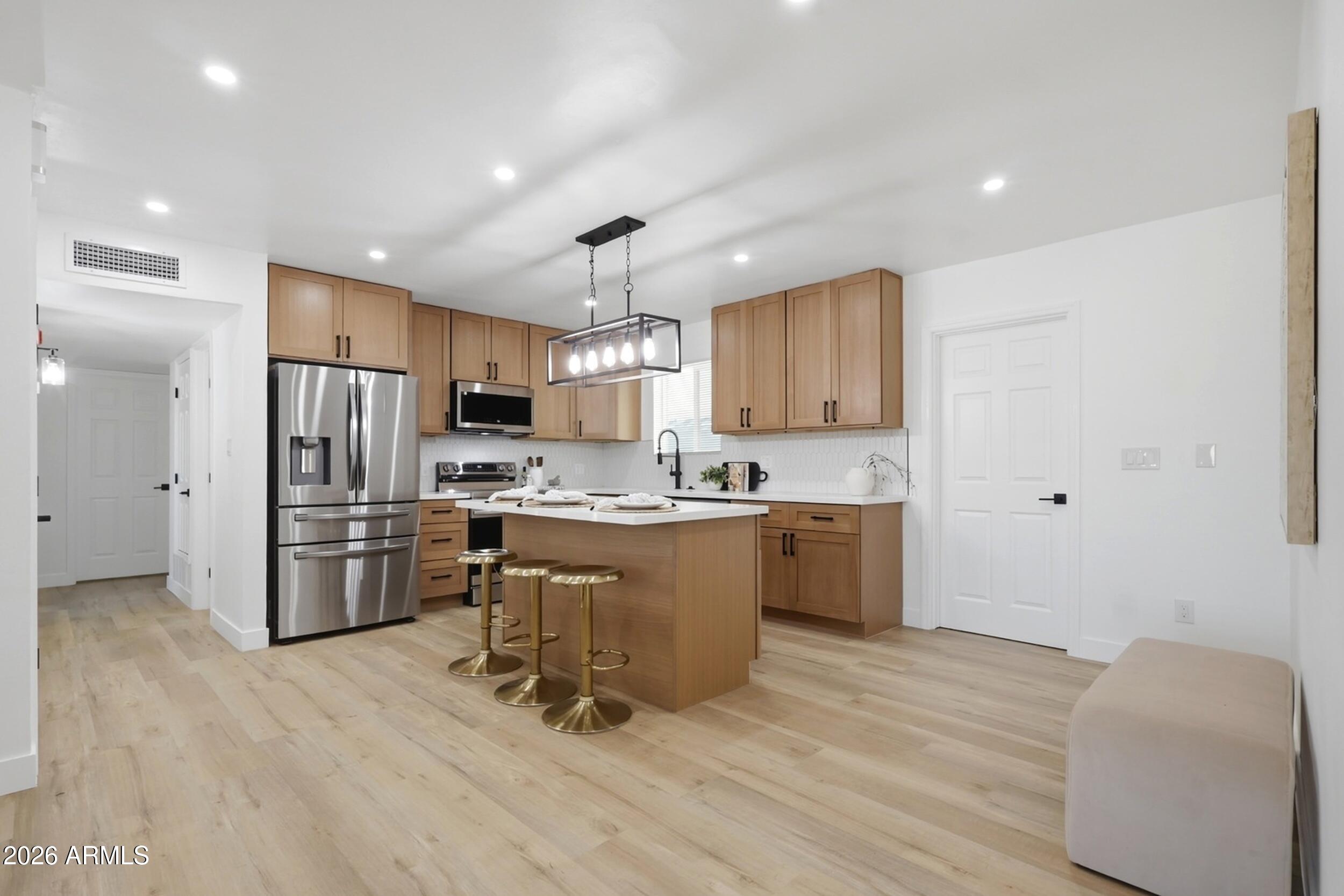 1555 West 6th Street Tempe, AZ 85281 - Photo 8 of 40 a kitchen with a refrigerator a sink and a stove top oven with wooden floor