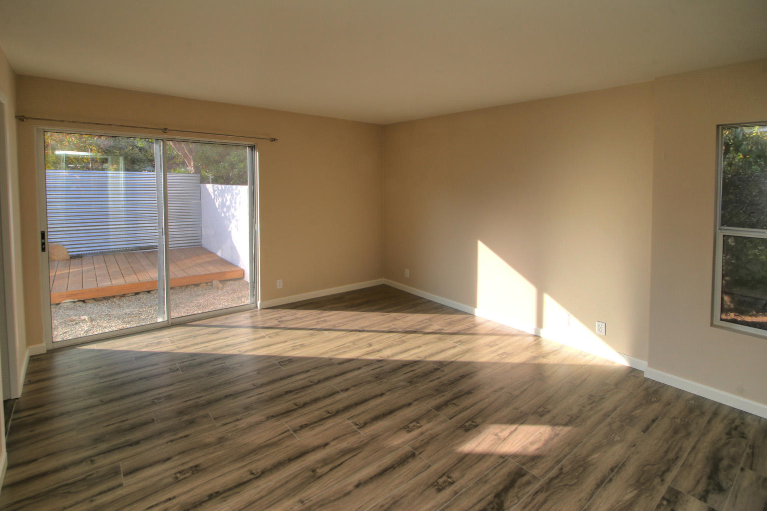 1275 Vallecito Road Carpinteria, CA 93013 - Photo 6 of 11 an empty room with wooden floor and windows
