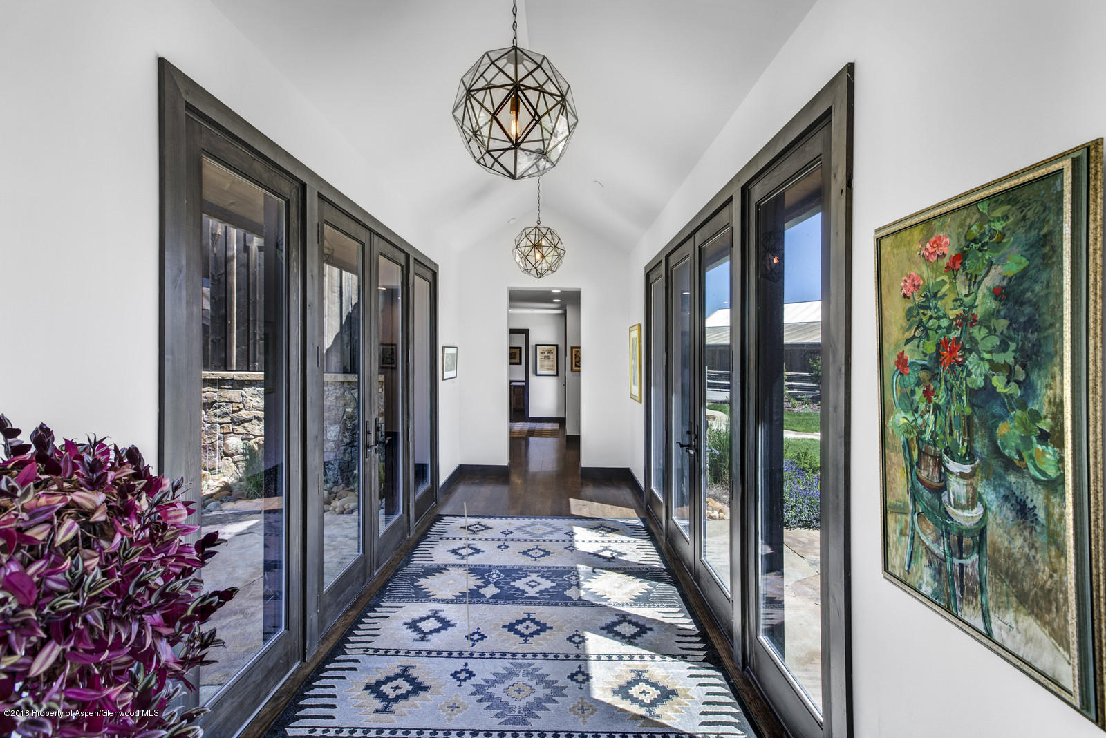 1003 Cattle Creek Ridge Road Carbondale, CO 81623 - Photo 12 of 57 a view of a hallway with wooden floor and a chandelier