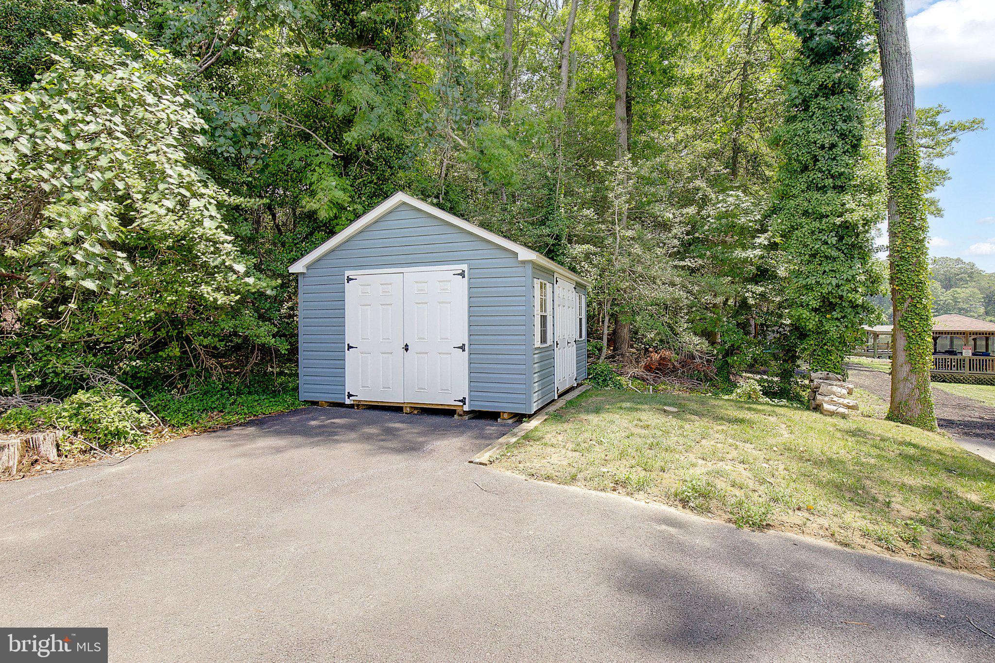 980 Apple Lane Solomons, MD 20629 - Photo 65 of 82 Charming shed nestled in lush greenery.