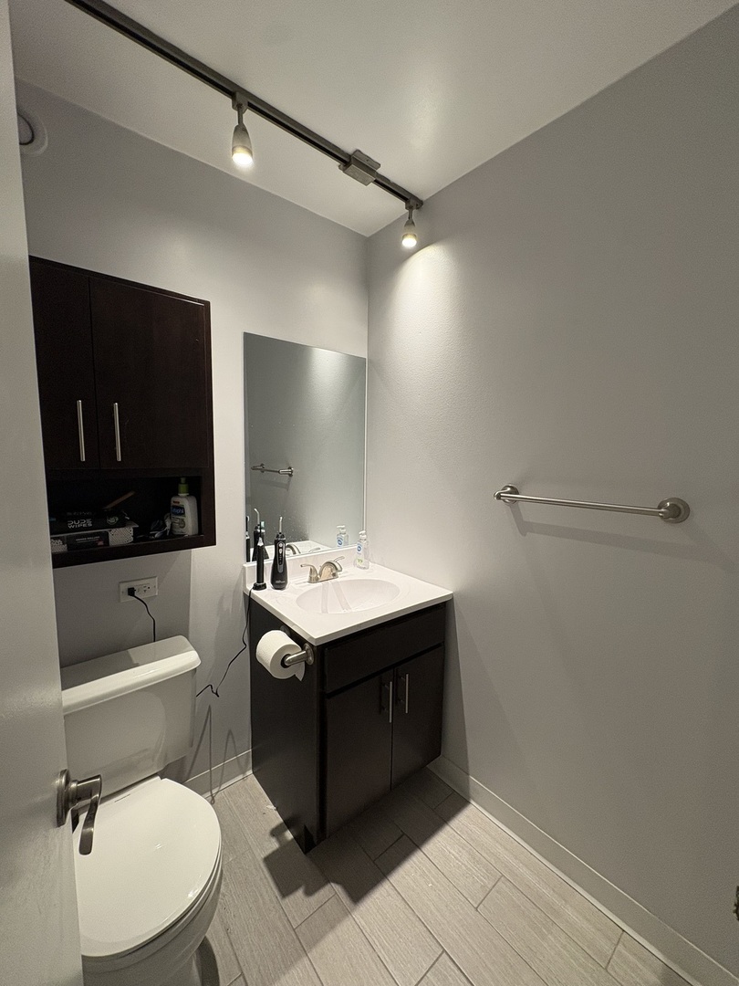 8 West Chestnut Street, Unit 21F Chicago, IL 60610 - Photo 10 of 19 a bathroom with a toilet sink and mirror
