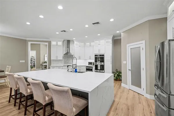 a kitchen with stainless steel appliances kitchen island granite countertop a refrigerator and a stove top oven
