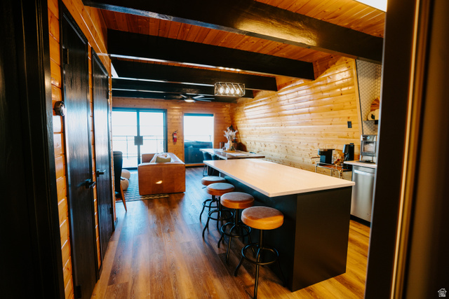 1413 Basel Drive Midway, UT 84049 - Photo 136 of 137 Kitchen with dark wood-style flooring, open floor plan, light countertops, a kitchen breakfast bar, and a wood ceiling with exposed beams