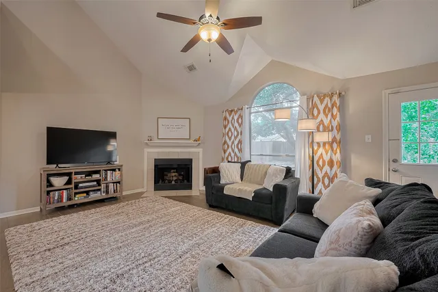 a living room with furniture a fireplace and a flat screen tv