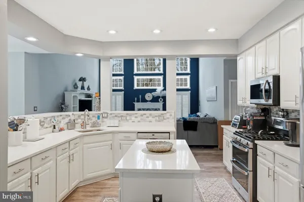 a kitchen with stainless steel appliances kitchen island granite countertop a sink and cabinets
