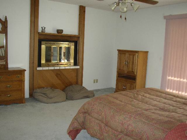 3213 Alcorn Road, Unit E1 Fallon, NV 89406 - Photo 6 of 8 a bedroom with a bed and a chandelier