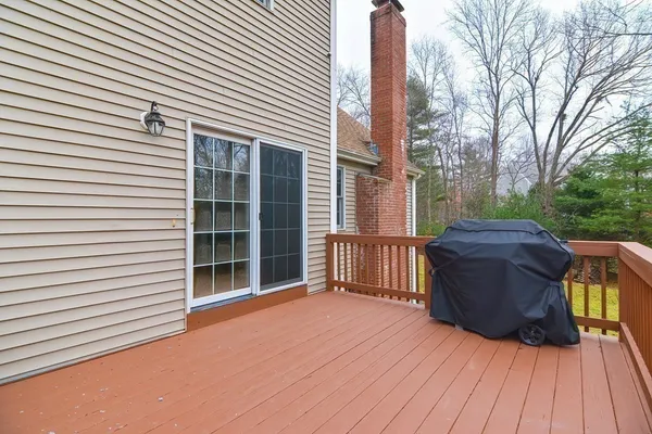 a view of a deck with wooden floor and fence and a floor to ceiling window
