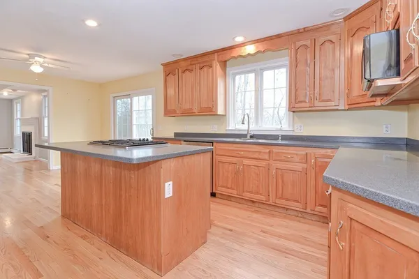 a kitchen with stainless steel appliances granite countertop a sink a stove cabinets and wooden floor