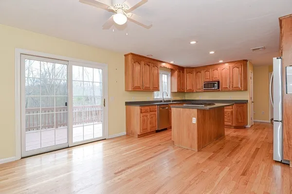 a kitchen with stainless steel appliances granite countertop a stove top oven a sink with wooden floors