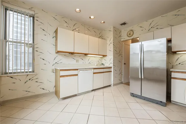 a kitchen with a refrigerator a sink and cabinets