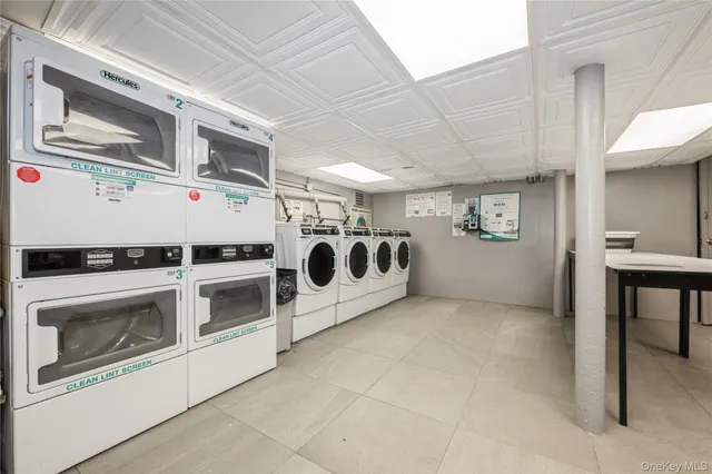 a utility room with stainless steel appliances and white cabinets