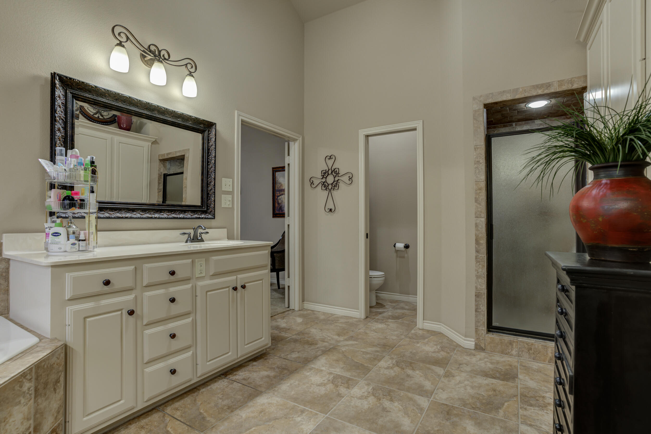 6008 89th Street Lubbock, TX 79424 - Photo 34 of 61 a spacious bathroom with double vanity a mirror and a shower