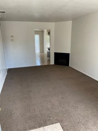 a view of empty room with wooden floor and fireplace