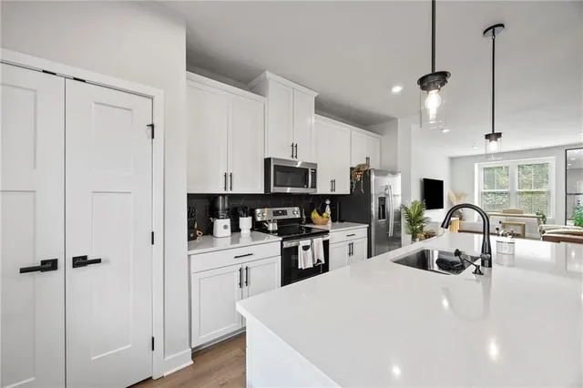 a kitchen with stainless steel appliances a refrigerator sink and microwave