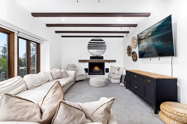 a living room with fireplace furniture and a large window