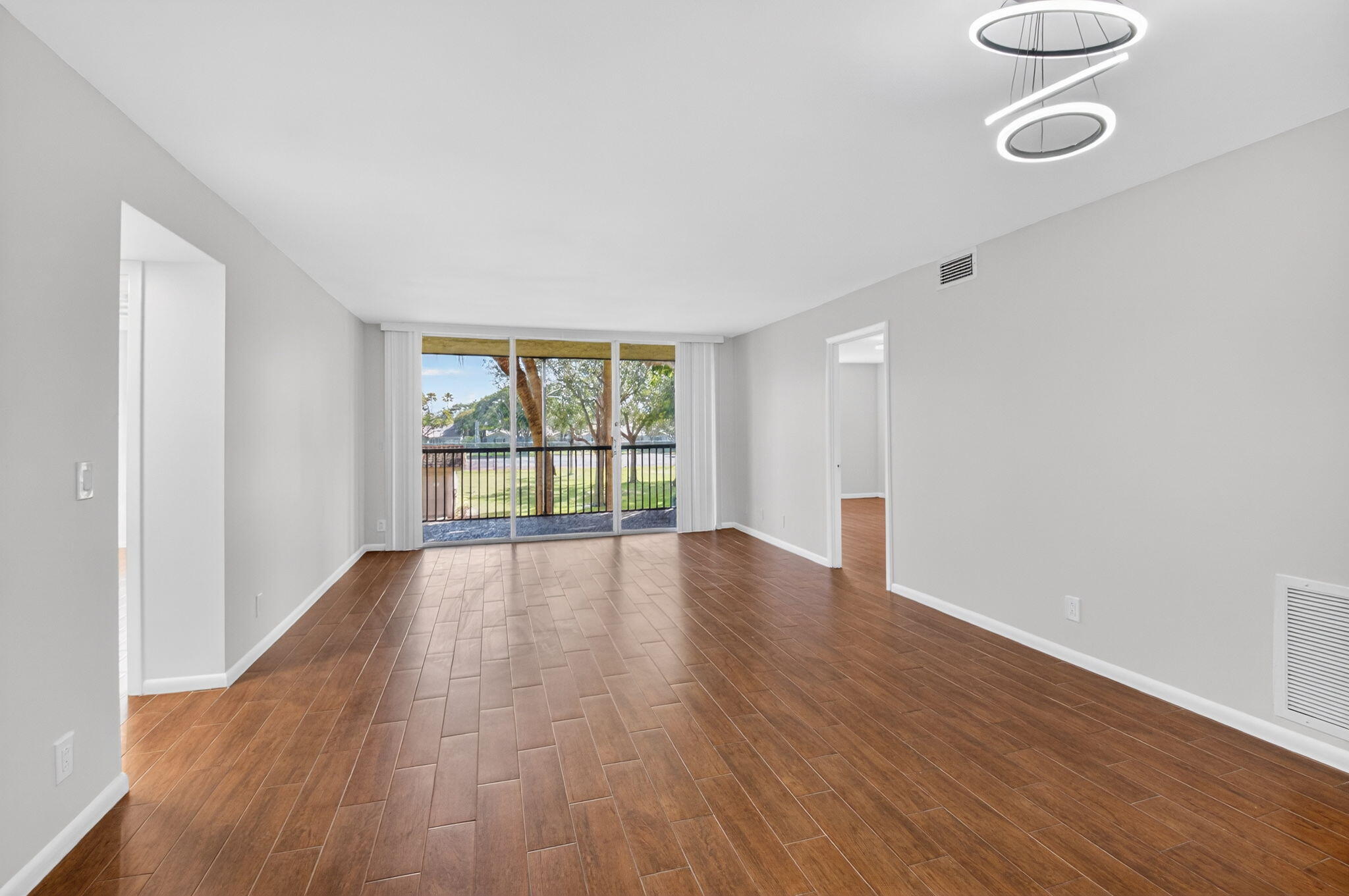 5260 Northwest 2nd Avenue, Unit 206 Boca Raton, FL 33487 - Photo 1 of 36 wooden floor in an empty room with a window