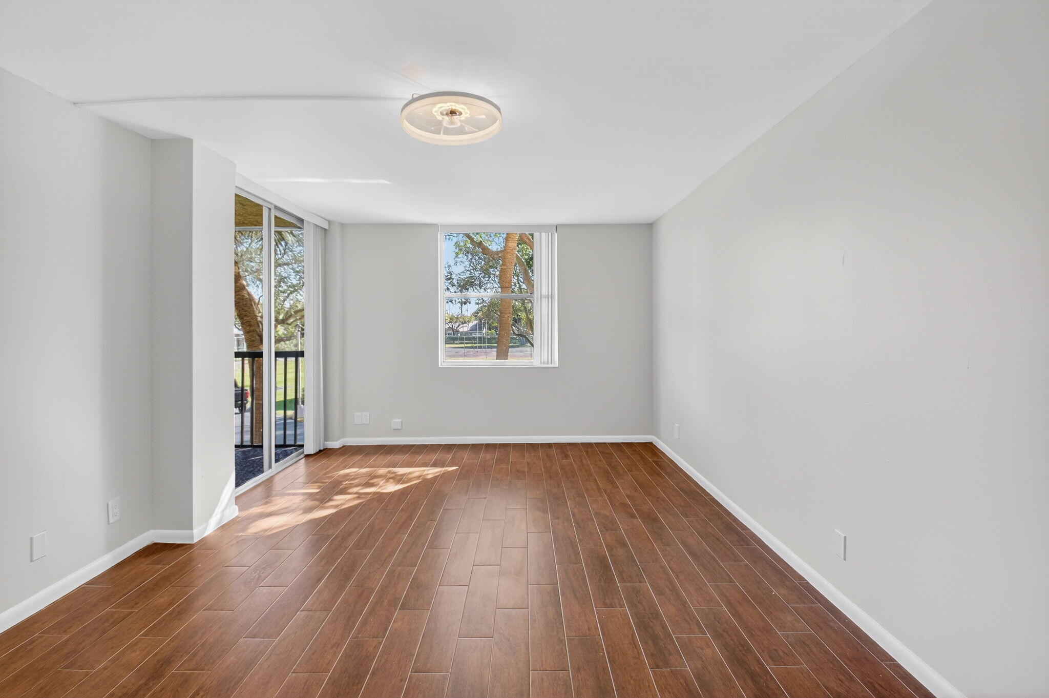 5260 Northwest 2nd Avenue, Unit 206 Boca Raton, FL 33487 - Photo 22 of 36 an empty room with wooden floor and windows
