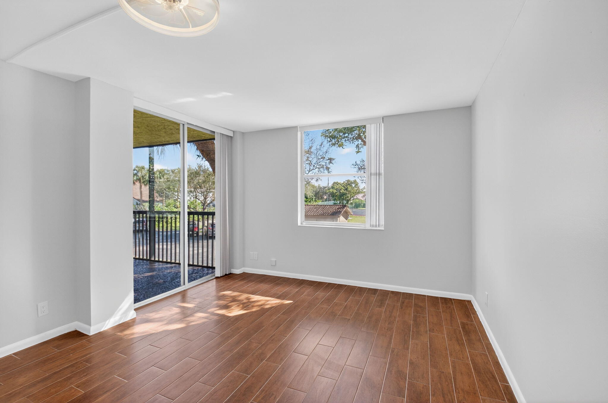 5260 Northwest 2nd Avenue, Unit 206 Boca Raton, FL 33487 - Photo 23 of 36 an empty room with wooden floor and windows