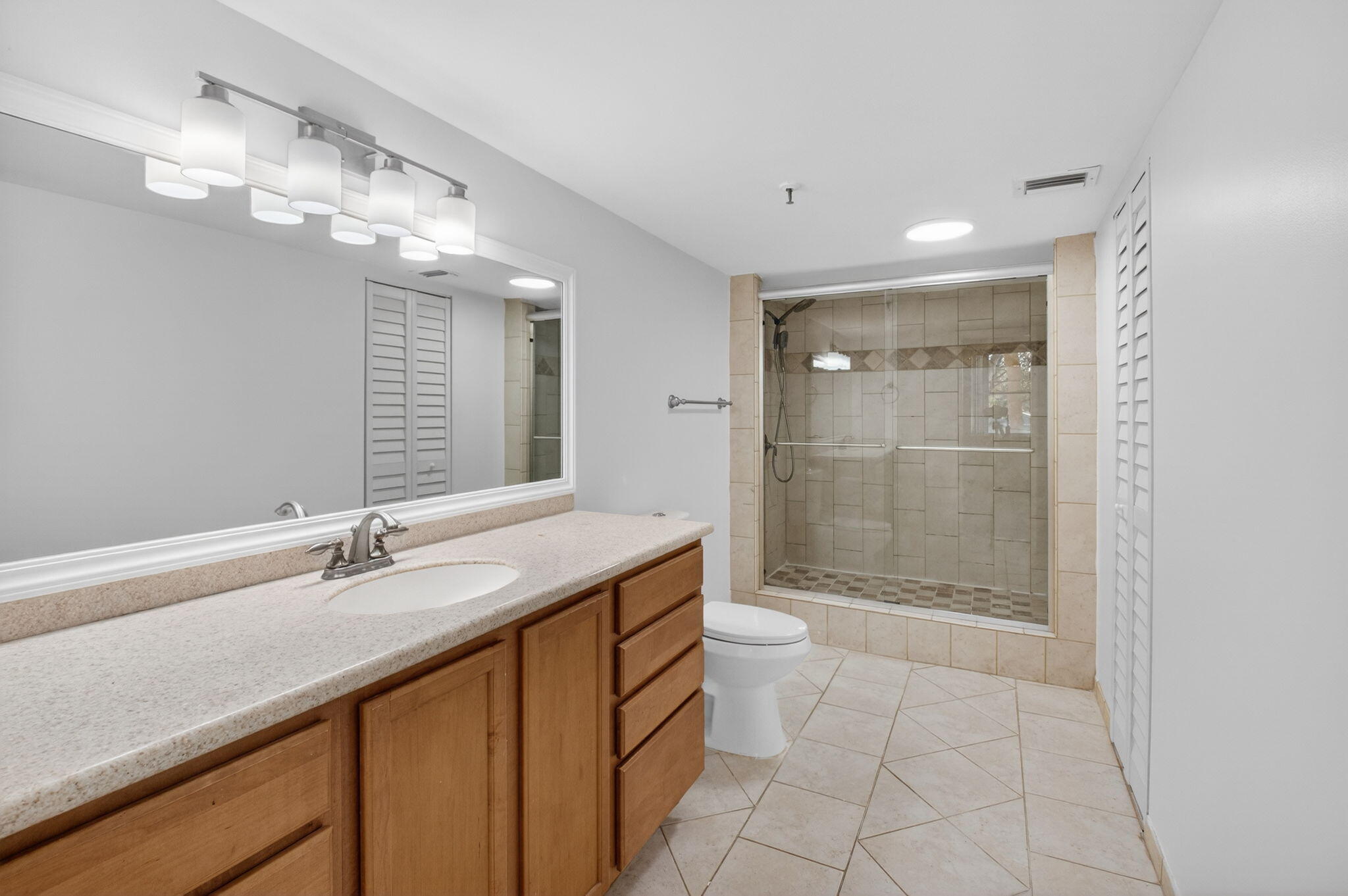 5260 Northwest 2nd Avenue, Unit 206 Boca Raton, FL 33487 - Photo 27 of 36 a bathroom with a granite countertop sink a toilet a mirror and shower