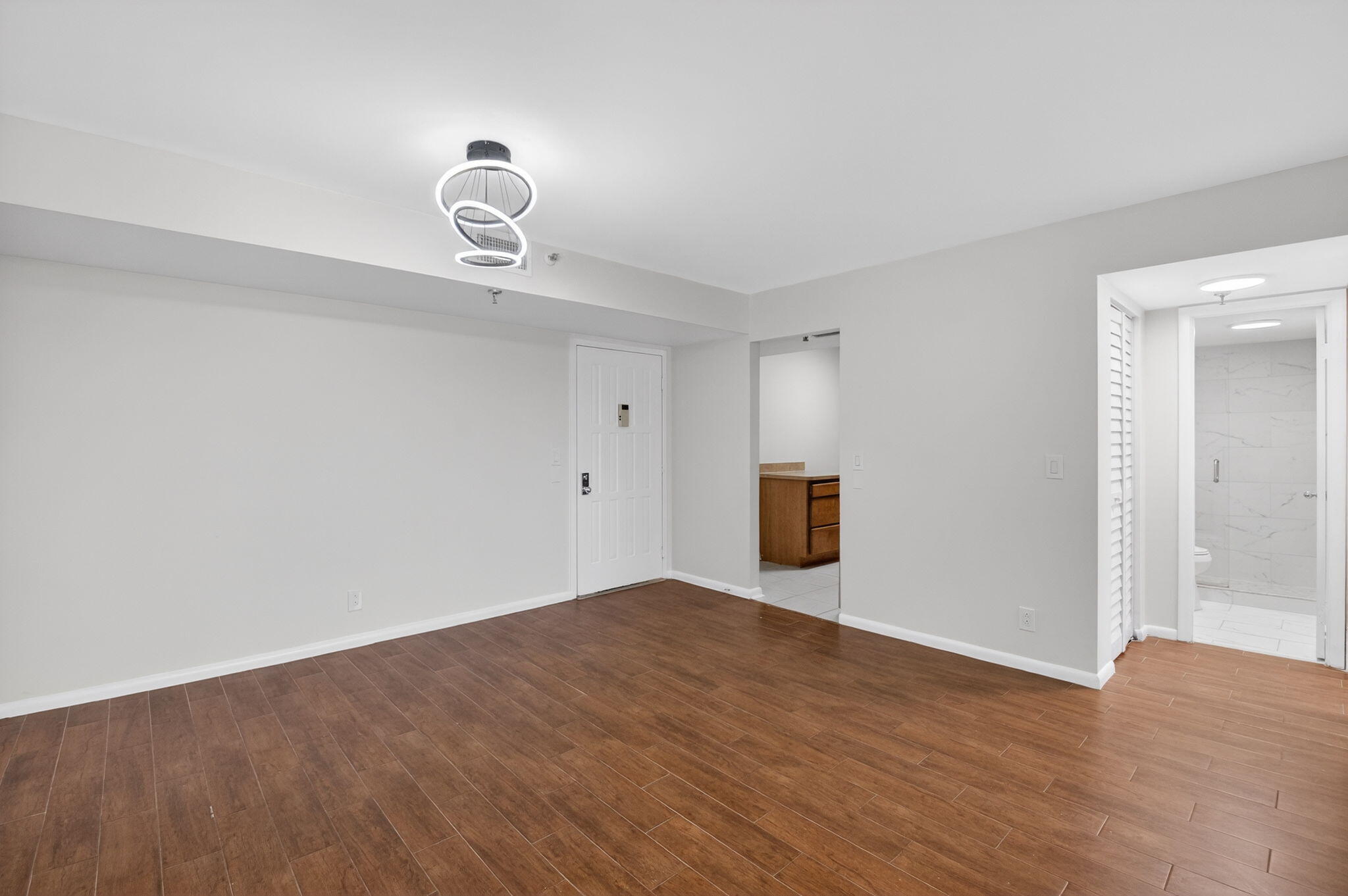 5260 Northwest 2nd Avenue, Unit 206 Boca Raton, FL 33487 - Photo 9 of 36 a view of an empty room with wooden floor and window