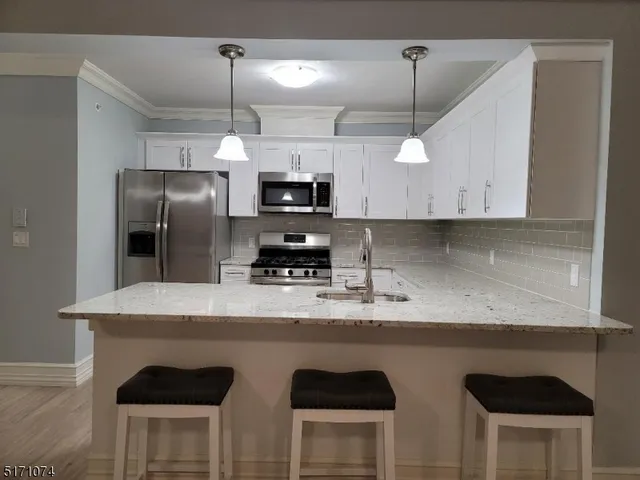 a kitchen with kitchen island white cabinets a refrigerator and a stove