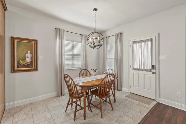 a dining room with furniture a chandelier and wooden floor