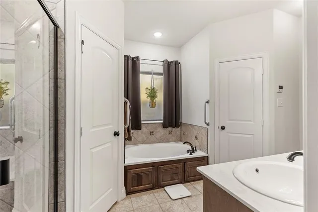 a bathroom with a tub sink and mirror