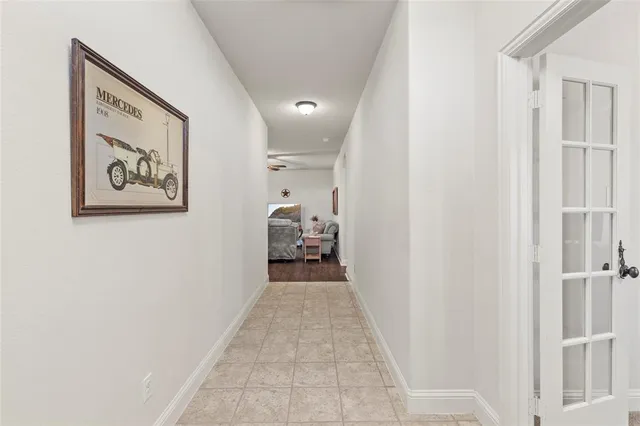 a view of a hallway with wooden floor and a bathroom