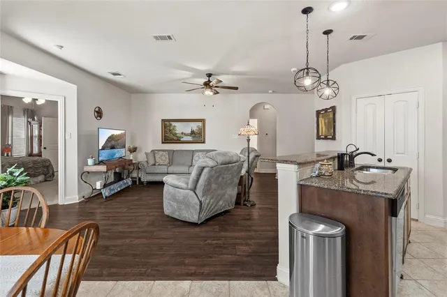a living room with furniture kitchen view and a chandelier