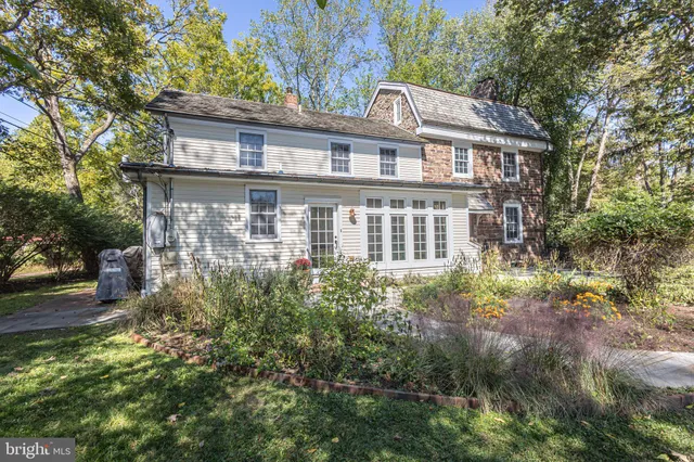 a bathroom with a granite countertop toilet a sink a mirror and a window