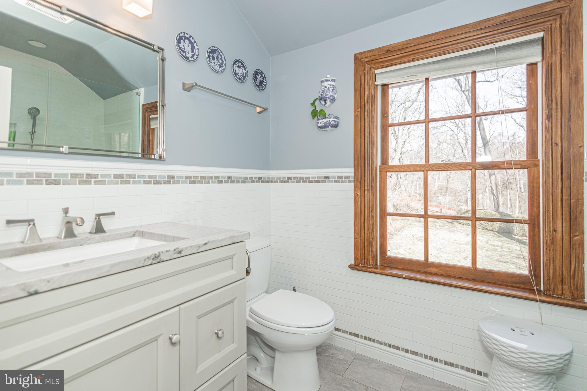 928 Taylorsville Road Washington Crossing, PA 18977 - Photo 27 of 106 a bathroom with a granite countertop toilet a sink a mirror and a window