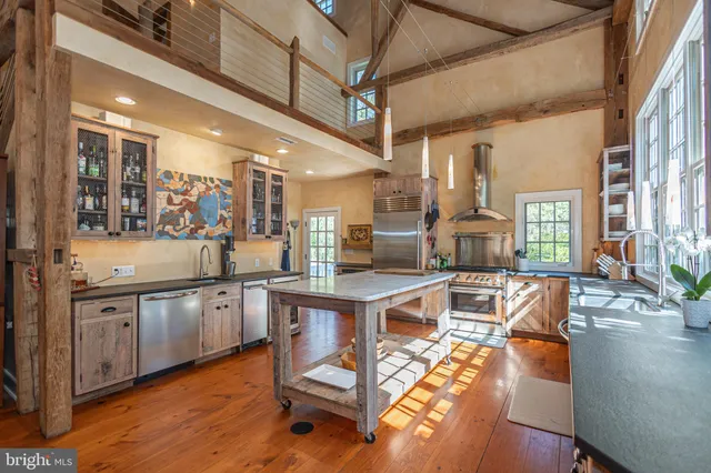 an aerial view of residential house with outdoor space and trees all around