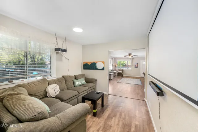 a kitchen with kitchen island granite countertop a stove a sink dishwasher and white cabinets with wooden floor