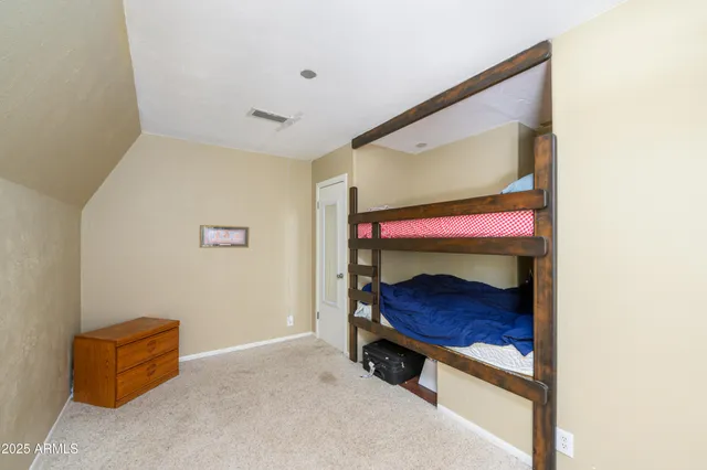 a room with a bed and a dresser