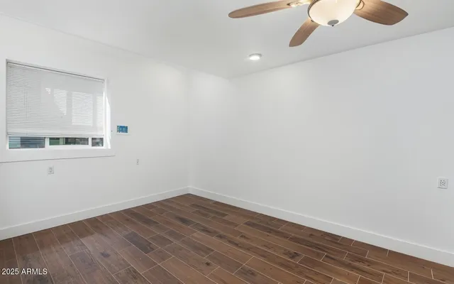 a view of a small space with wooden floor and a window