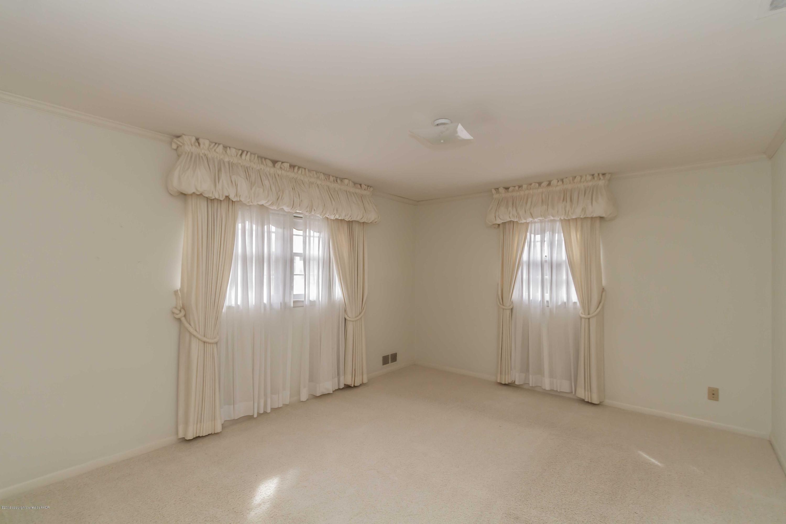 3228 South Travis Street Amarillo, TX 79109 - Photo 27 of 44 an empty room with chandelier fan and windows