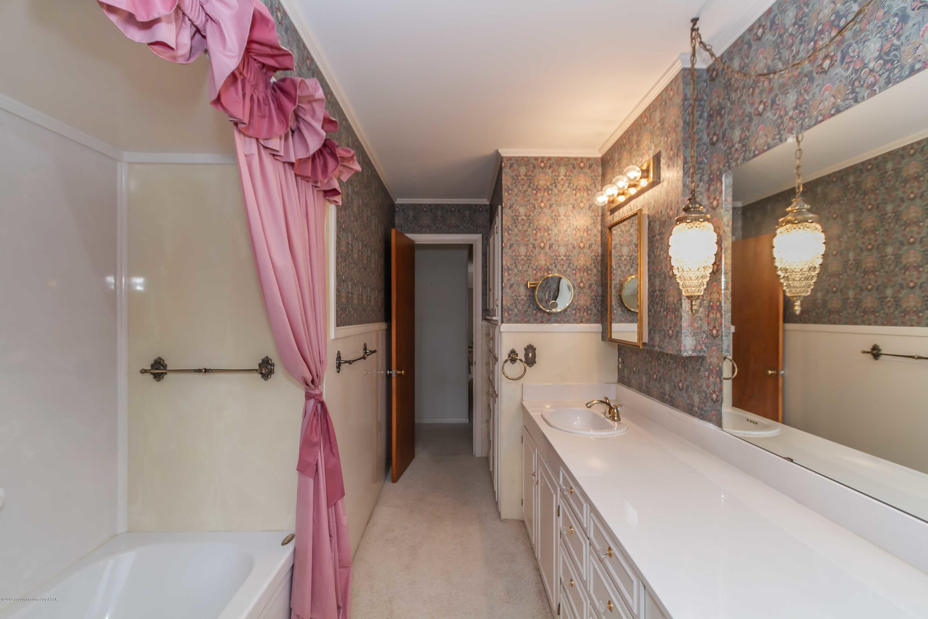 3228 South Travis Street Amarillo, TX 79109 - Photo 36 of 44 a bathroom with a bathtub sink and mirror