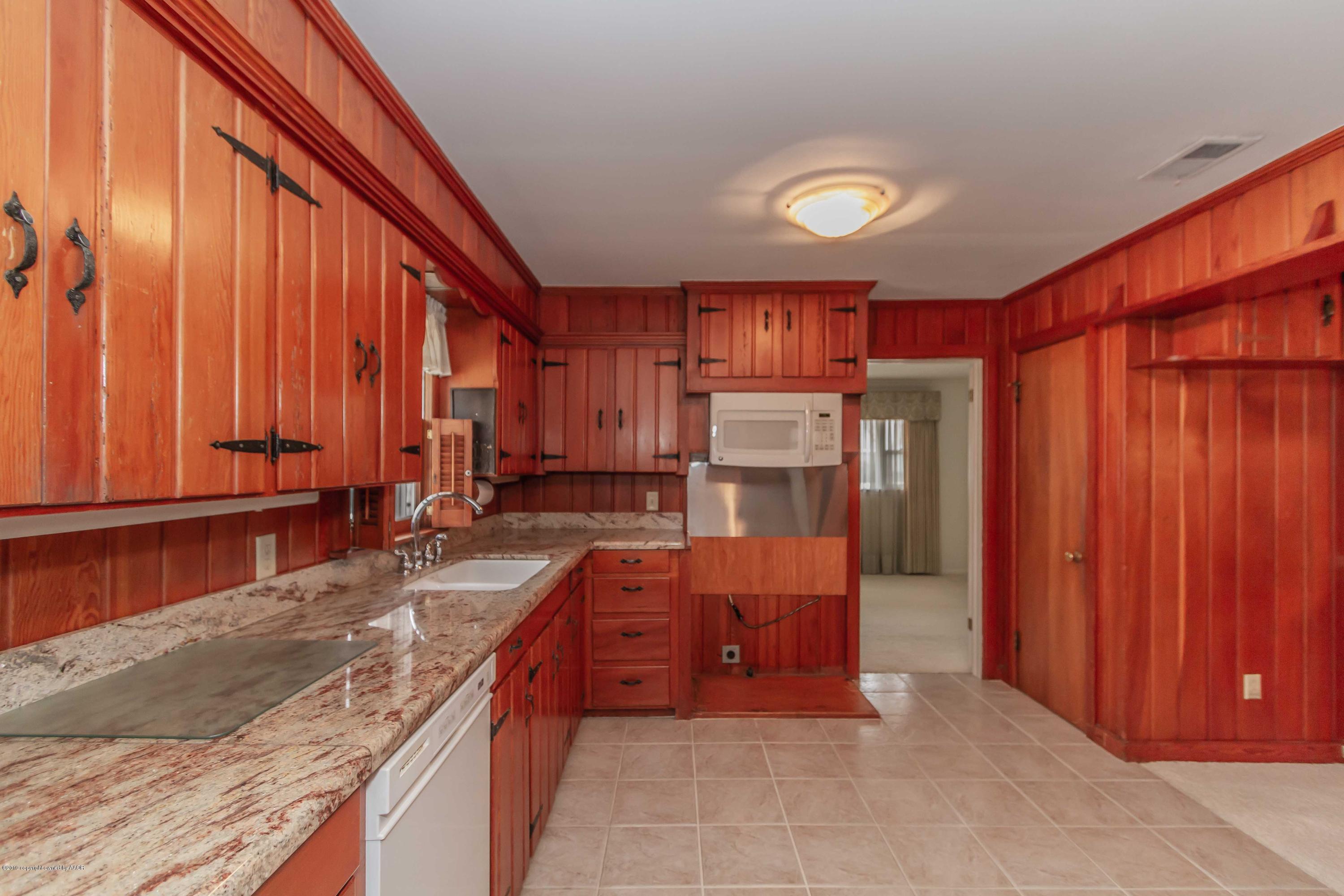 3228 South Travis Street Amarillo, TX 79109 - Photo 10 of 44 a kitchen with stainless steel appliances granite countertop a stove a sink and a refrigerator