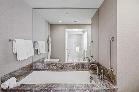 a bathroom with a tub sink and mirror