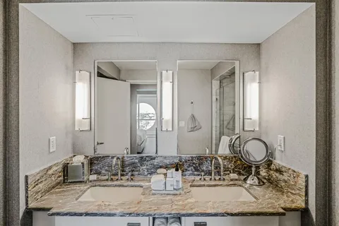 a bathroom with a granite countertop sink and a mirror