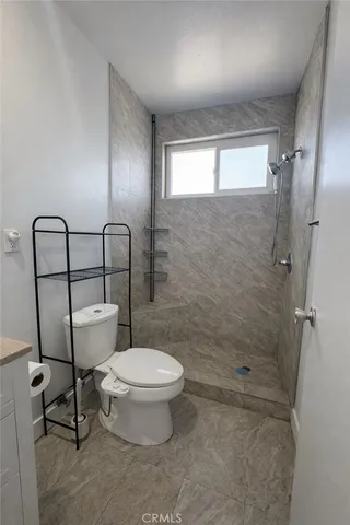 a bathroom with a toilet and a shower