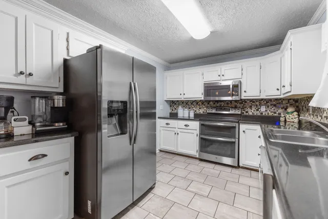 a kitchen with a refrigerator sink and cabinets