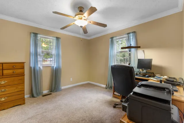 a view of a workspace with furniture and a window