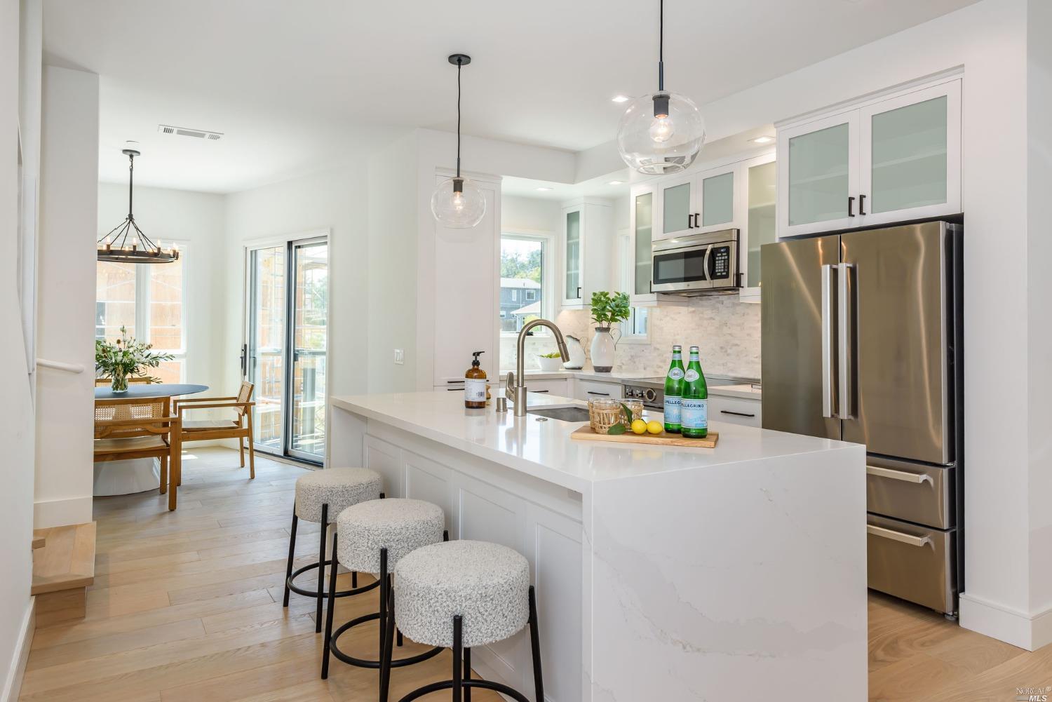 1072 Foster Road Napa, CA 94558 - Photo 5 of 28 a kitchen with stainless steel appliances a refrigerator a sink dishwasher a dining table and chairs with wooden floor