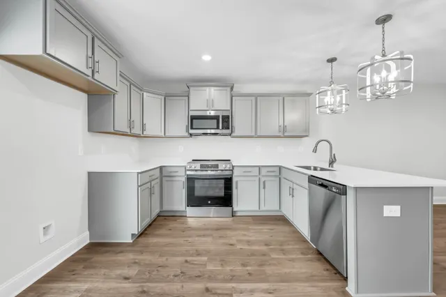 a kitchen with kitchen island granite countertop a sink cabinets and stainless steel appliances